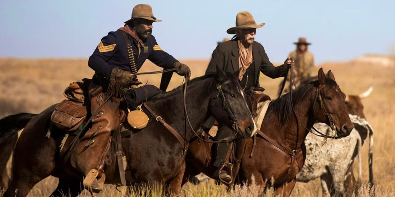 LaMonica Garrett as Thomas and Sam Elliott as Shea ride horses in 1883