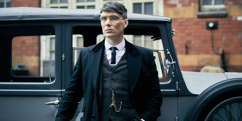 Tommy Shelby standing outside a car in Peaky Blinders.