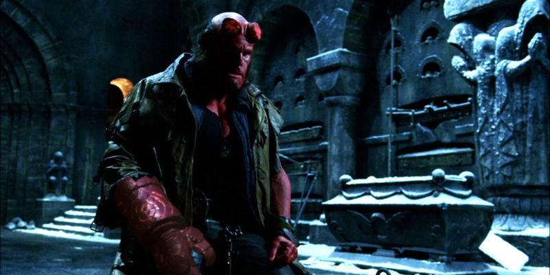 Ron Perlman as Hellboy in Hellboy (2004) with his hands on his legs