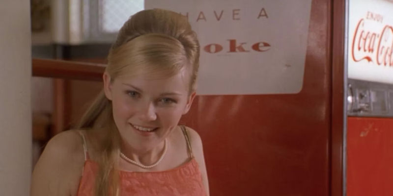 Kirsten Dunst's Verena looking delighted beside a Coke machine in All I Wanna Do 1998