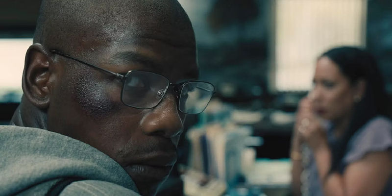 Brian Brown-Easley (John Boyega) staring over his shoulder in an office in Breaking