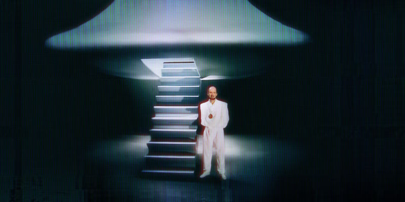 A man standing in front of a fake alien spaceship in Rael: The Alien Prophet