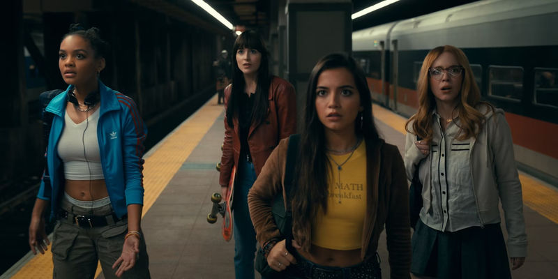 Cassie and the girls stand on the train platform in Madame Web