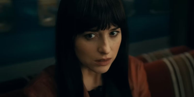 Cassie sits on a train in Madame Web