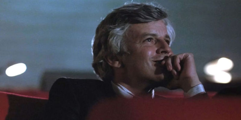 Tony watching a movie in the theater in Cinema Paradiso