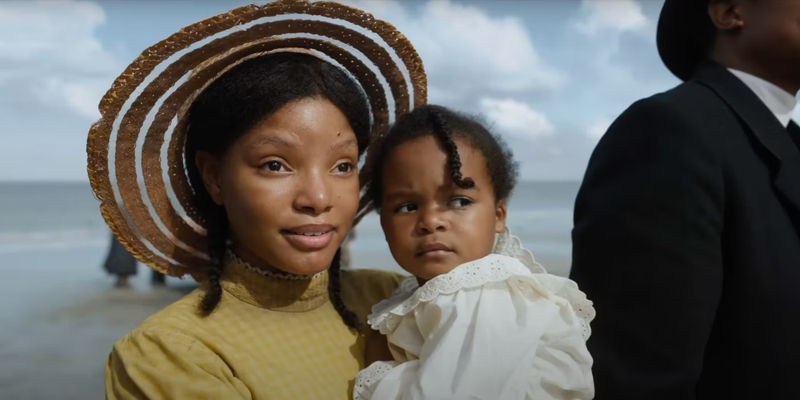 Halle Bailey as young Nettie, holding a baby in The Color Purple 2023