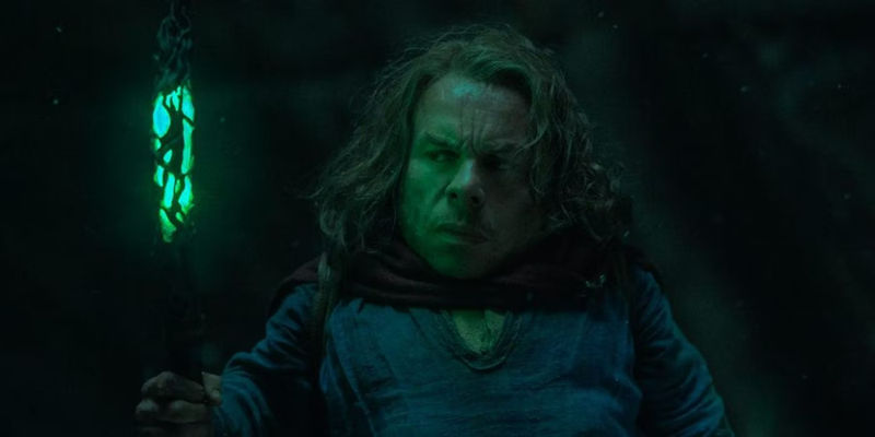 Willow (Warwick Davis) holding a glowing green staff in Willow.