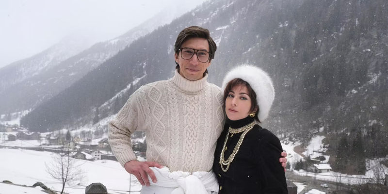 Adam Driver (Maurizio Gucci) and Lady Gaga (Patrizia Reggiani) smiling outside in the snow for House of Gucci