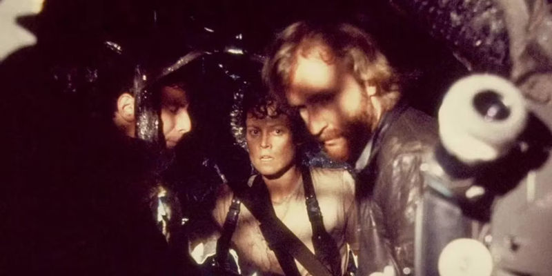 ridley scott and sigourney weaver on the set of aliens preparing to shoot deleted scene with cocooned burke