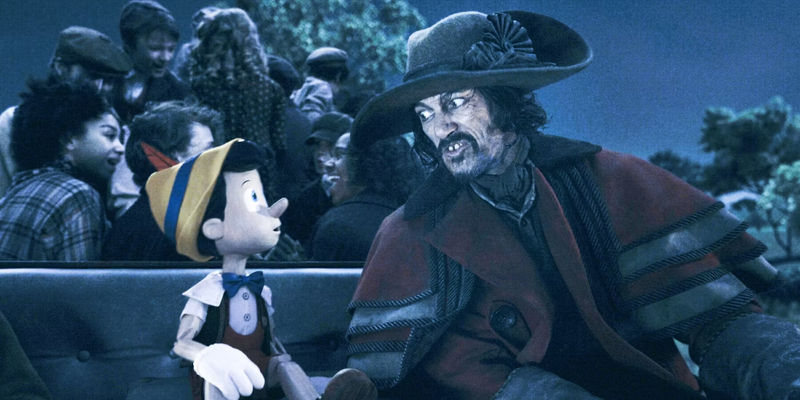 The Coachman (Luke Evans) talking to Pinocchio with children in the back of his carriage.