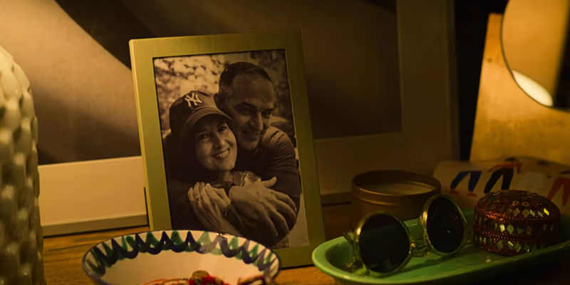 Two people smile in the picture in Mack's apartment in Players