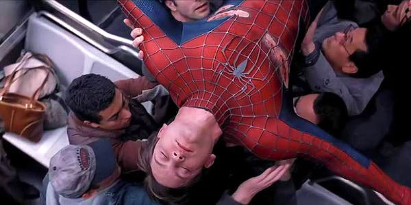 Tobey Maguire as Spider-Man being carried by train passengers in Spider-Man 2