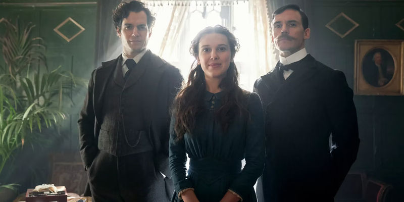 Millie Bobby Brown as Enola Holmes, Henry Cavill as Sherlock Holmes, and Sam Claflin as Mycroft Holmes in a still from Enola Holmes.