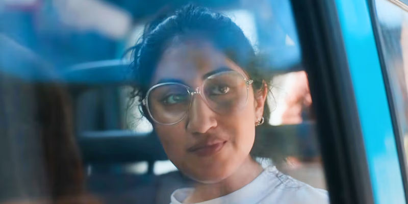 Emma Morley looking in thought through a car window