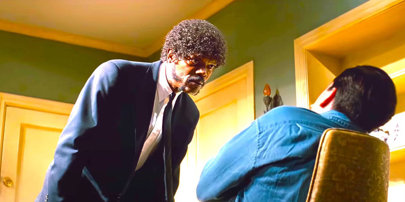 Samuel L. Jackson leaning in menacingly while interrogating Frank Whaley in a dramatic scene from Pulp Fiction