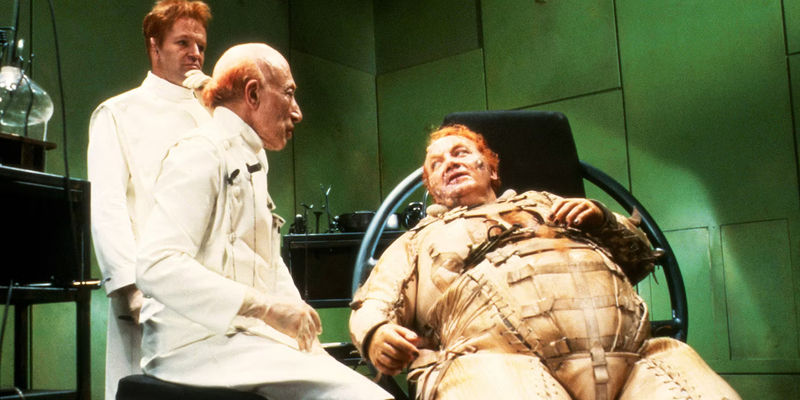Baron Harkonnen reclined in a chair next to doctors in Dune 1984 - Why Dune 1984's Harkonnens Were So Problematic