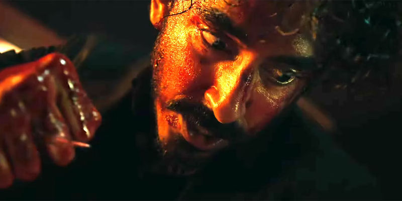 Monkey Man Dev Patel covered in blood with a stick between his fist