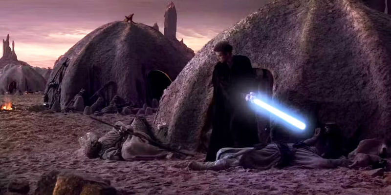 Anakin with his blue lightsaber drawn and dead Tusken Raiders on either side of him. - Star Wars: Episode II - Attack of the Clones - Why Did Padmé Not Care About The Tusken Raider Massacre?
