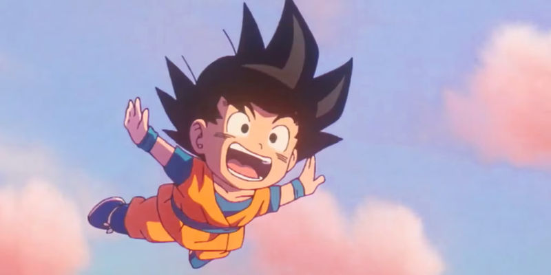 Screenshot from Dragon Ball Daima show a young Goku flying in the clouds with a big smile on his face and no training symbol on his Gi.