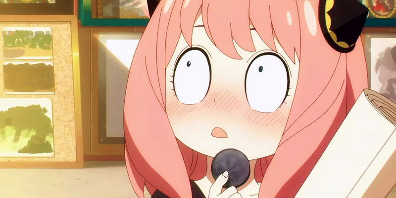 Anya from Spy x Family thinking and holding a macaron.