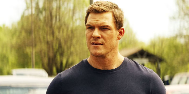 Alan Ritchson as Jack Reacher with cuts on his face in the Prime Video show Reacher