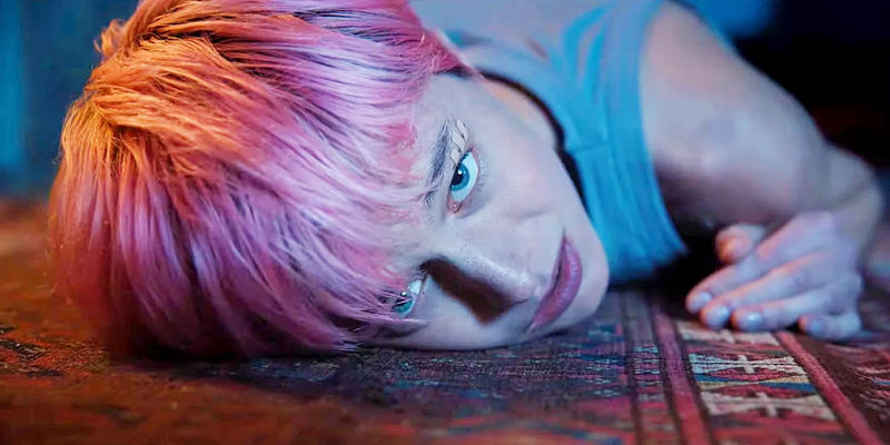 Emma Corrin with her face pressed to the carpet in A Murder at the End of the World.