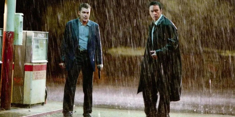 John Cusack and Ray Liotta stand in the rain looking surprised in Identity