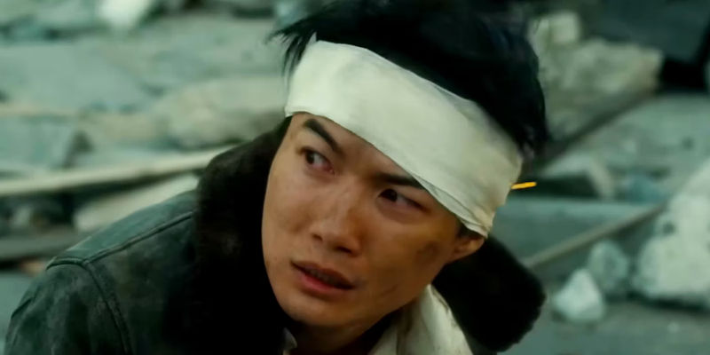 Ryunosuke Kamiki as Kōichi Shikishima Standing in Rubble with a Bandaged Head in Godzilla Minus One