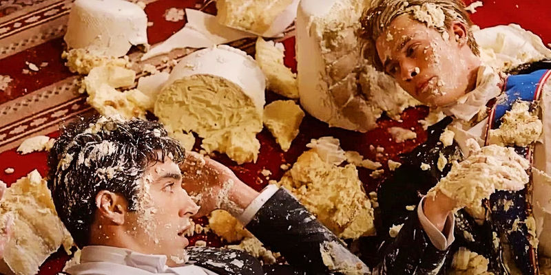 Alex and Henry covered in cake in Red White and Royal Blue