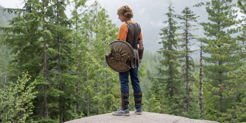 Walker Scobell standing on a cliff and holding a shield in Percy Jackson and the Olympians