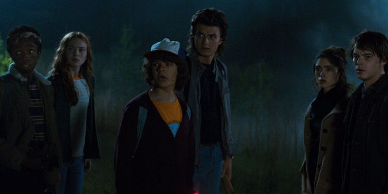 The cast of Stranger Things in a field at night