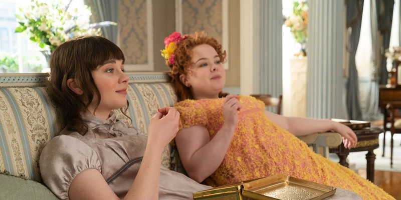 Penelope and Eloise Eating on a Sofa in Bridgerton Season 1
