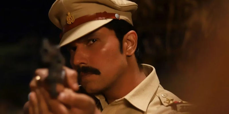 Randeep Hooda as Inspector Avinash Mishra pointing a gun and looking serious.
