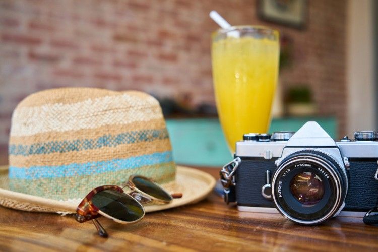 Glasses, camera, hat on a table