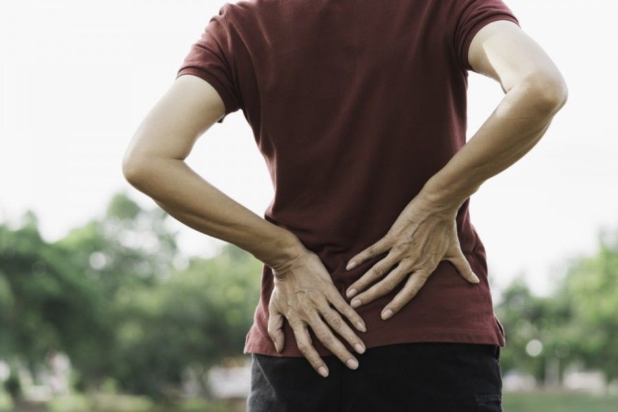 Woman holding lower back due to pain