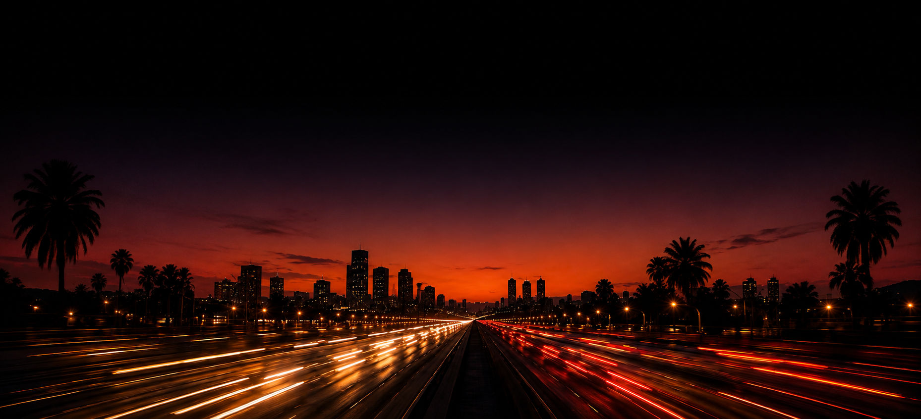 A highway leading toward the Kinshasa skyline at sunset