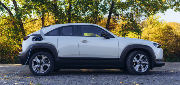A stationary electric car plugged into a charger