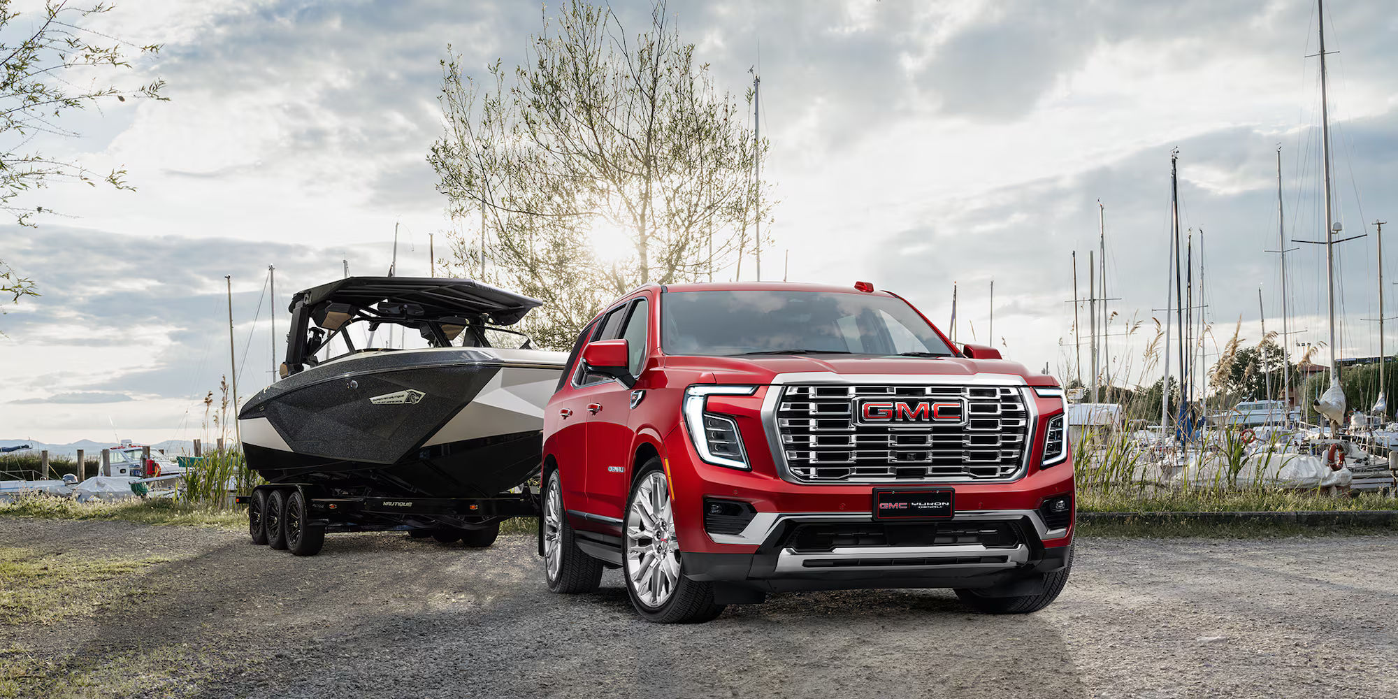 Red Yukon Denali towing a large boat