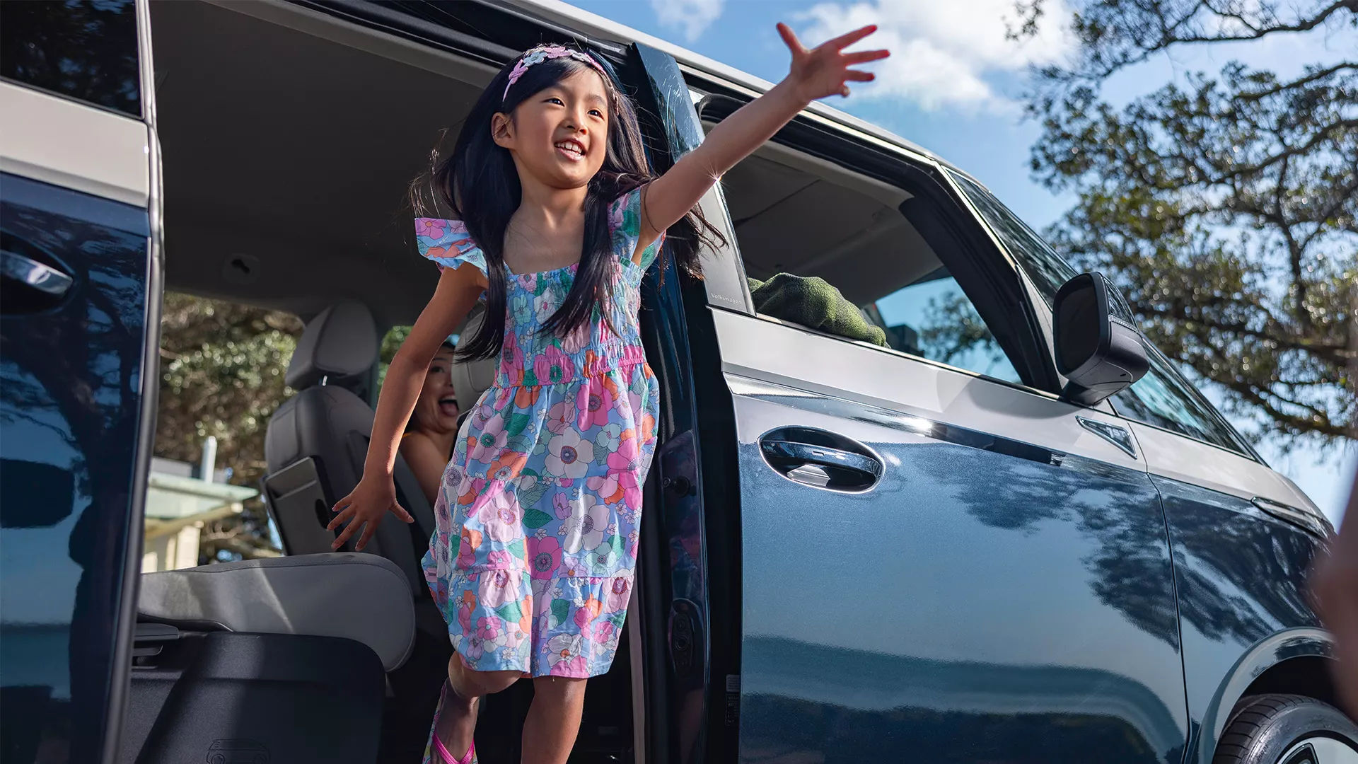 Girl jumping out of a VW ID Buzz