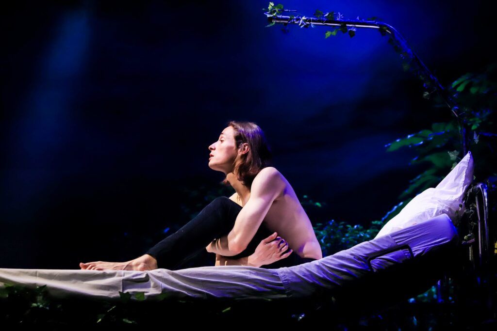 Comédien du spectacle Cicatriciel assis sur un lit d’hôpital.