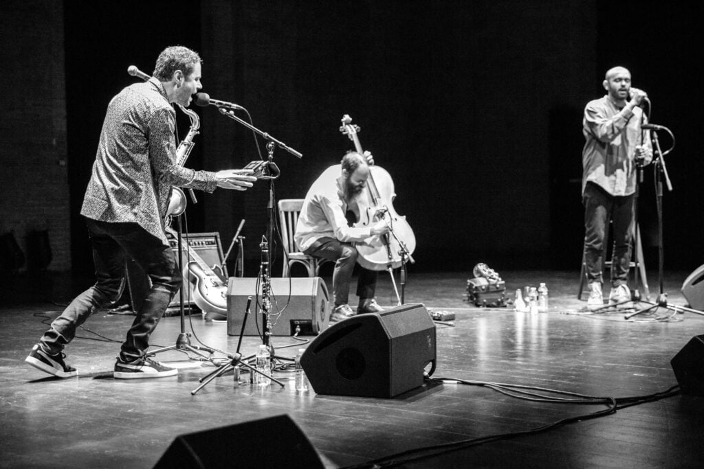 Photographie en noir et blanc des musiciens sur la scène