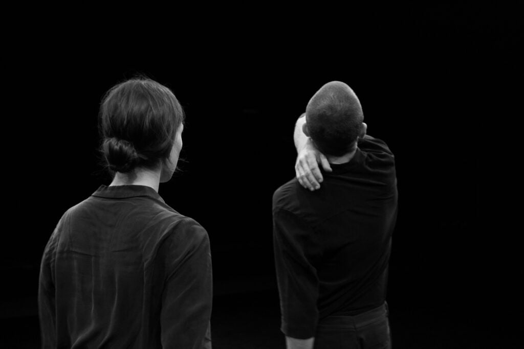 Photographie des danseurs du spectacle The Gyre de dos en noir et blanc