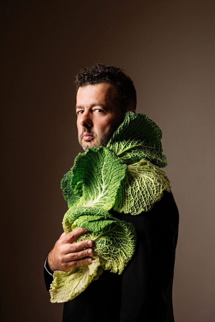 Portrait de Daniel Zimmermann avec des feuilles de chou qui recouvrent son costume