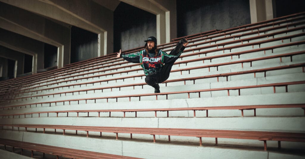 Un homme se tient le pied dans la main en sautant.