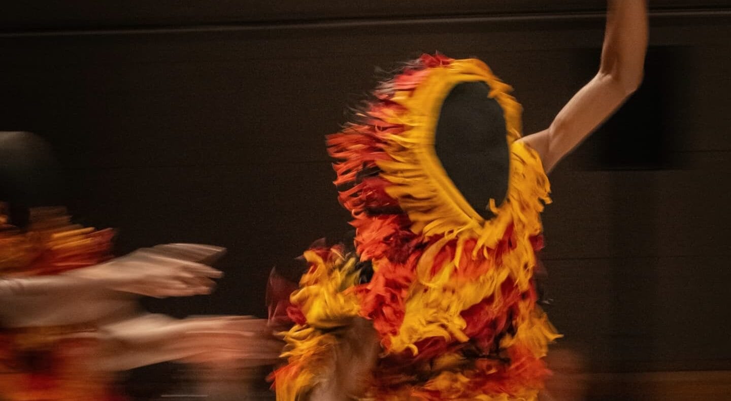 un danseur court en portant un masque traditionnel africain.