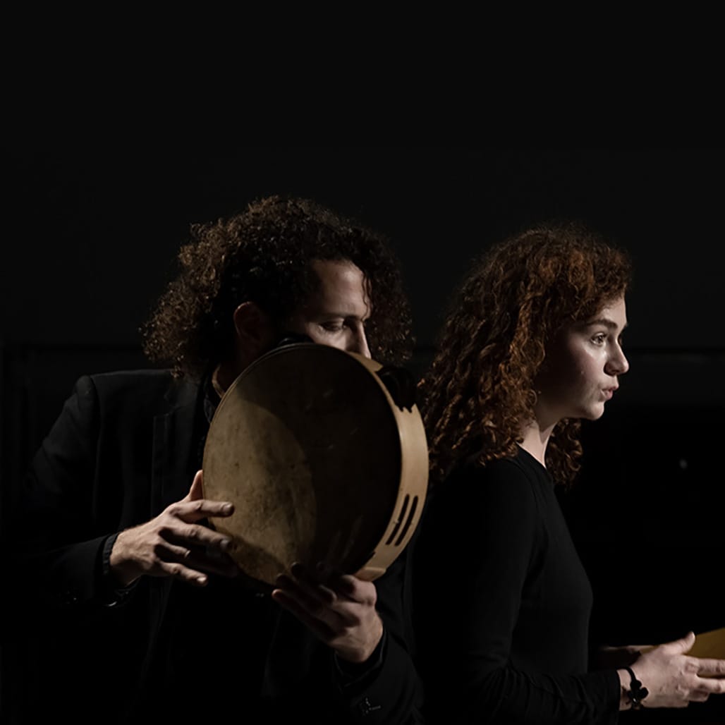 profils d'une jeune comédienne et d'un musicien percussionniste sur fond noir.