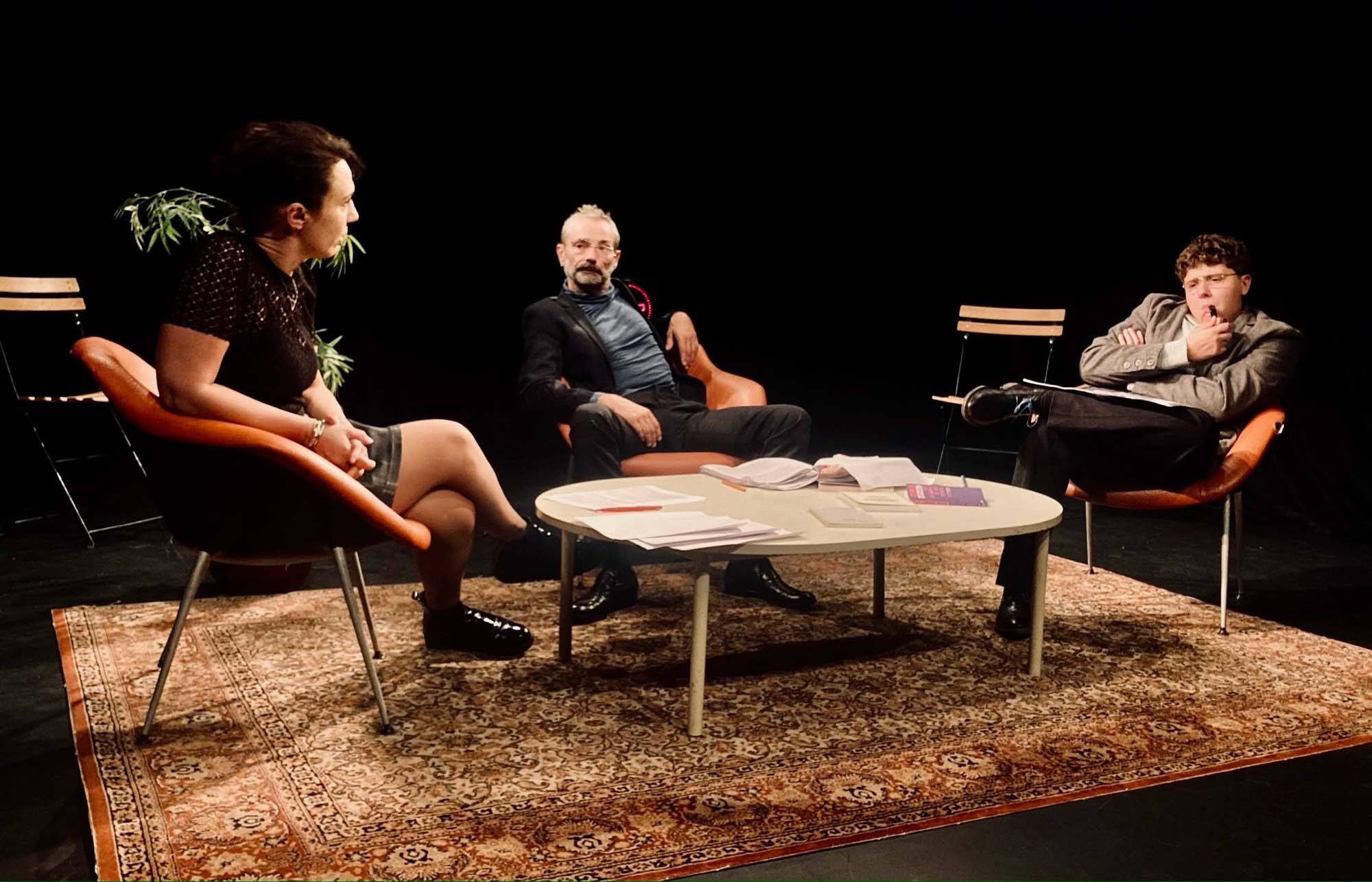 Une femme et deux hommes assis autour d'une table basse