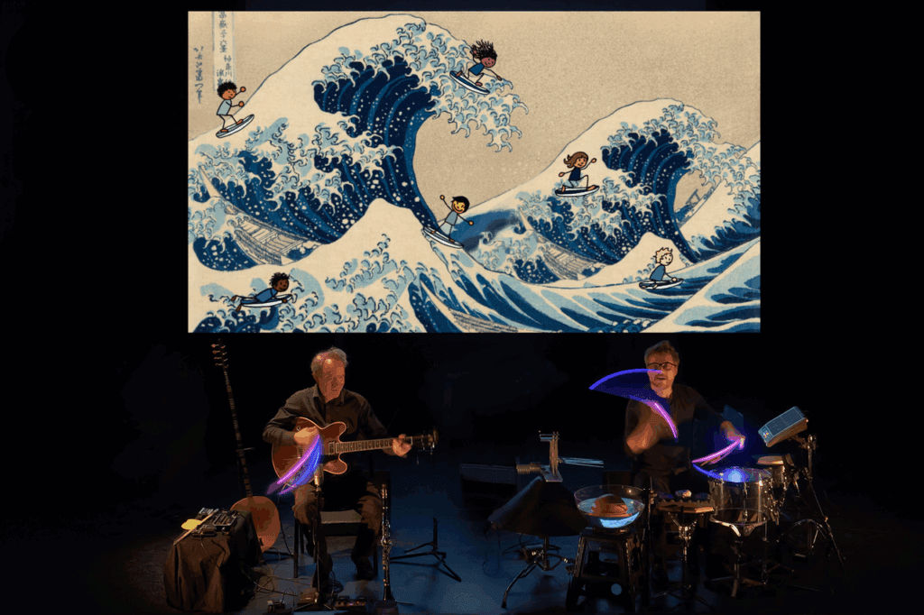 2 musiciens jouent devant un écran représentant La Vague d'Hokusaï