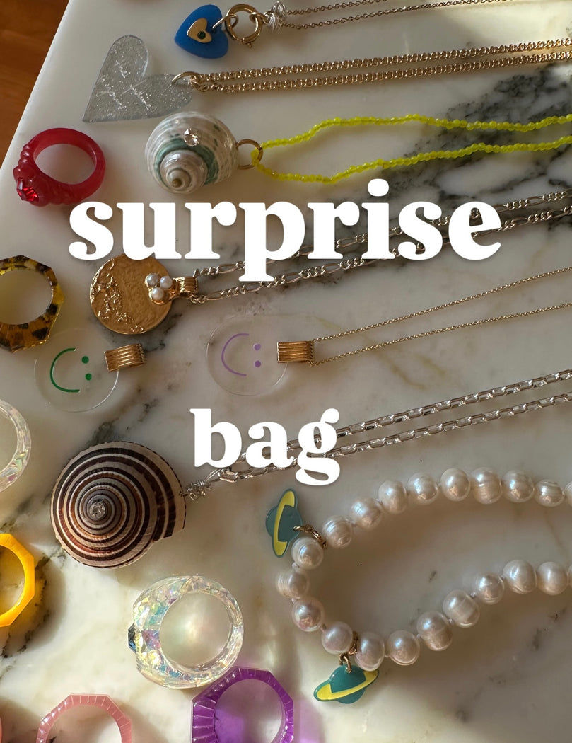 Various WALD Berlin jewelry and accessories are stylishly arranged on a marble surface with the text 