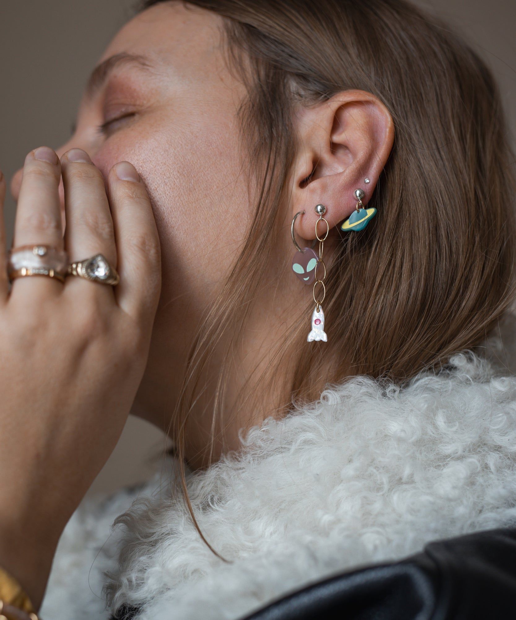 A woman wearing a fur jacket and WALD Berlin's From Another Mother Galactic Earring Set.